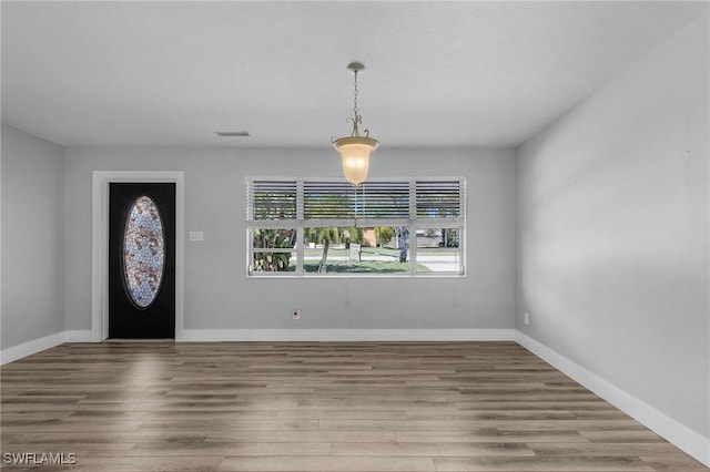 foyer with wood finished floors, visible vents, and baseboards