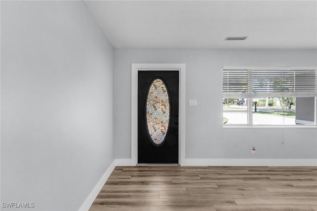 foyer with wood finished floors, visible vents, and baseboards