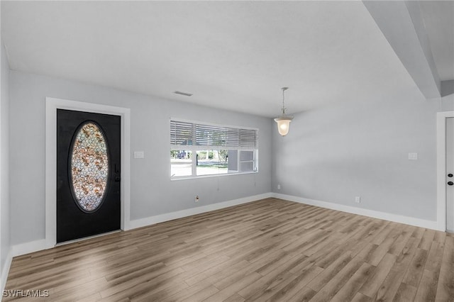 foyer with wood finished floors, visible vents, and baseboards