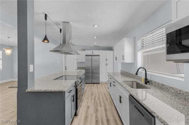 kitchen with appliances with stainless steel finishes, white cabinets, a sink, island range hood, and light stone countertops