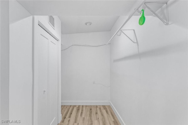 spacious closet featuring wood finished floors and visible vents