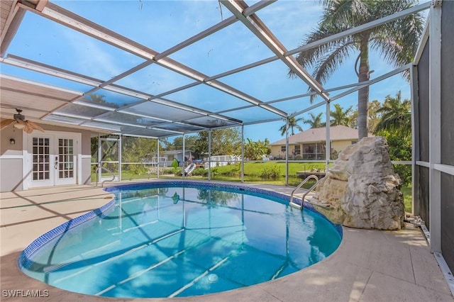 outdoor pool featuring a patio area, glass enclosure, and french doors