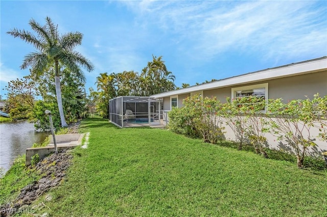 view of yard featuring a water view and glass enclosure