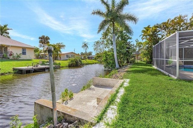 exterior space with a lanai, a water view, and a yard