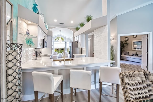 16380 Kelly Woods Dr, Fort Myers, FL 33908 - kitchen featuring sink, hardwood / wood-style flooring, a breakfast bar, stainless steel appliances, and kitchen peninsula