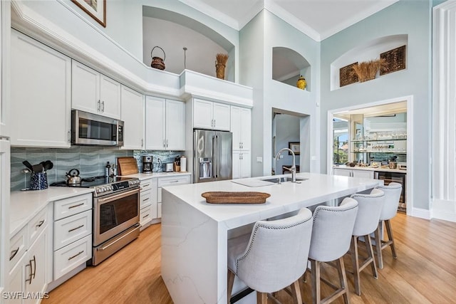 kitchen with white cabinetry, an island with sink, appliances with stainless steel finishes, and sink