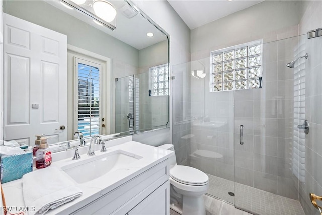 bathroom with an enclosed shower, vanity, and toilet