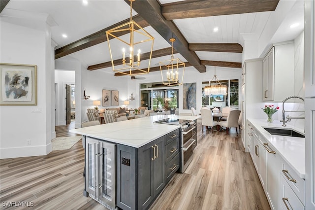 kitchen with a notable chandelier, double oven range, light wood-type flooring, and a sink