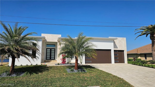 contemporary house with driveway, a front yard, a garage, and stucco siding