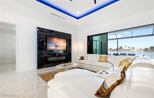 413 SW 46th Ter, Cape Coral, FL 33914 - living room featuring a water view, baseboards, marble finish floor, and a premium fireplace