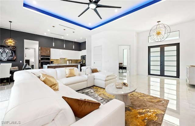 413 SW 46th Ter, Cape Coral, FL 33914 - living area featuring a tray ceiling, ceiling fan with notable chandelier, marble finish floor, and a towering ceiling