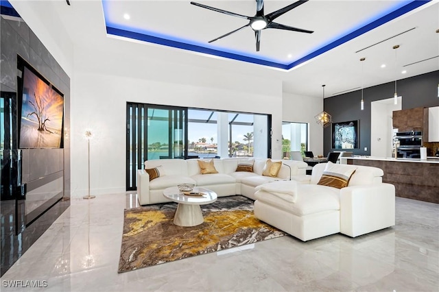 413 SW 46th Ter, Cape Coral, FL 33914 - living area featuring marble finish floor, a high ceiling, a raised ceiling, and a ceiling fan