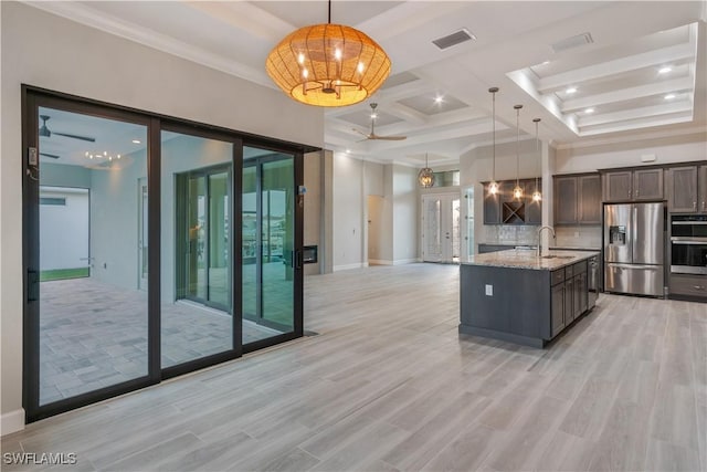 4320 Vasco St, Punta Gorda, FL 33950 - kitchen with visible vents, light stone counters, open floor plan, hanging light fixtures, and stainless steel appliances