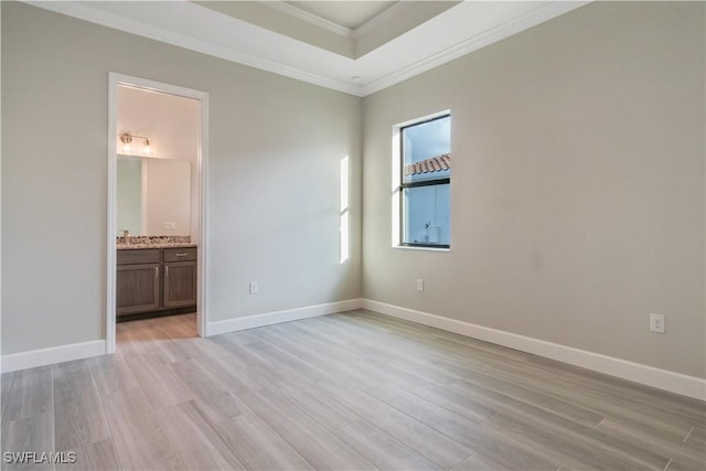 4320 Vasco St, Punta Gorda, FL 33950 - unfurnished bedroom with connected bathroom, baseboards, light wood-style floors, a raised ceiling, and crown molding