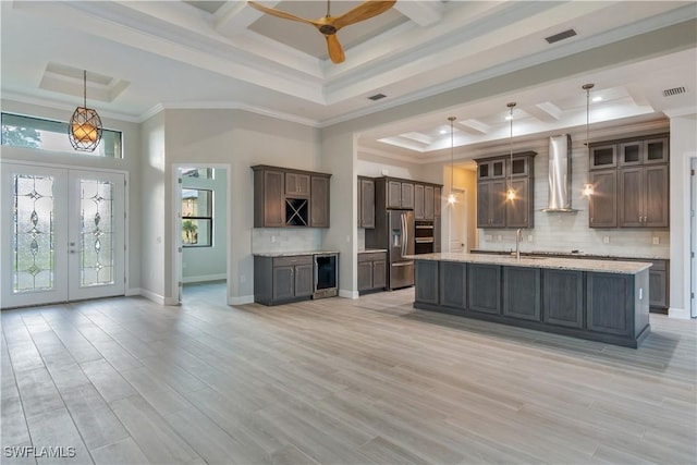 4320 Vasco St, Punta Gorda, FL 33950 - kitchen with wall chimney exhaust hood, wine cooler, stainless steel fridge, and pendant lighting