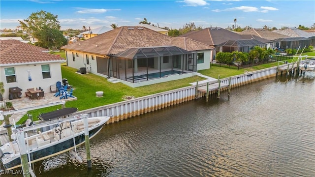 4320 Vasco St, Punta Gorda, FL 33950 - back of house with a lawn, glass enclosure, boat lift, a residential view, and a water view
