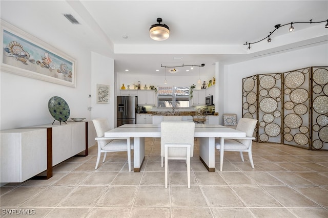 dining space featuring rail lighting, visible vents, and light tile patterned floors