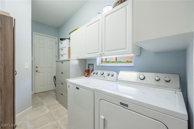 clothes washing area featuring baseboards, cabinet space, and washer and dryer