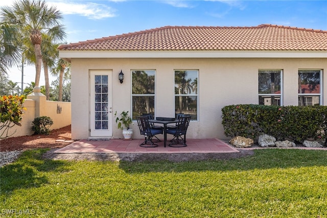 back of property featuring a yard, a patio, fence, and stucco siding