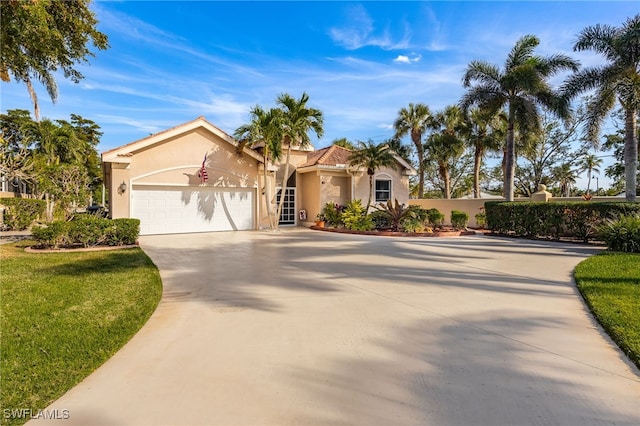 mediterranean / spanish-style house featuring a garage, concrete driveway, and stucco siding