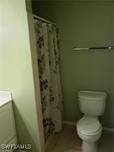 bathroom featuring a shower with curtain, vanity, and toilet