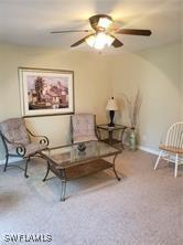 living area featuring carpet floors and ceiling fan