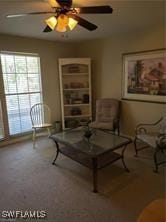 carpeted living room with ceiling fan