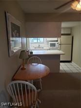 kitchen with white fridge and light tile patterned floors