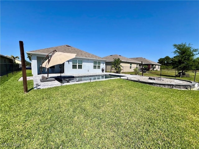 back of property with a yard, a fenced in pool, and a patio area