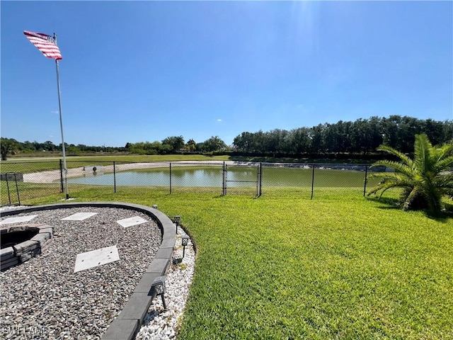 view of yard featuring a water view and an outdoor fire pit