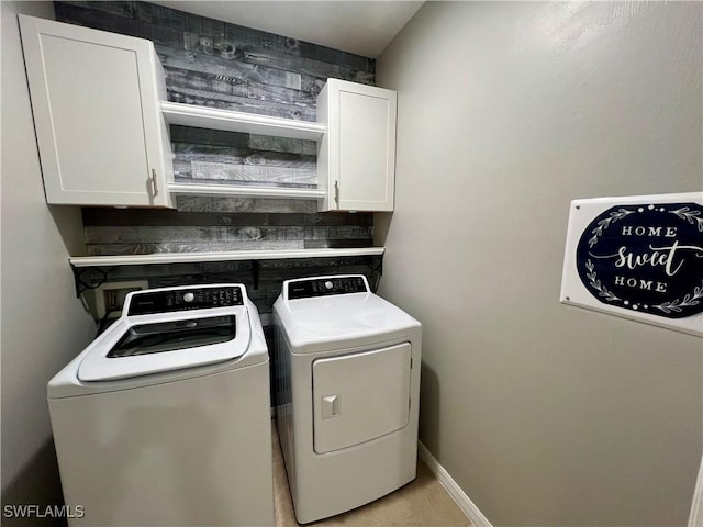 washroom with cabinets and washing machine and clothes dryer