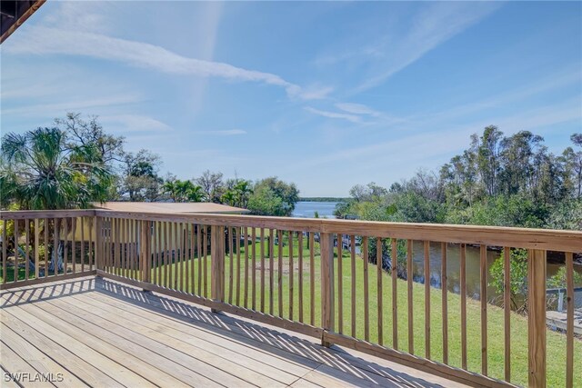 wooden terrace with a lawn and a water view