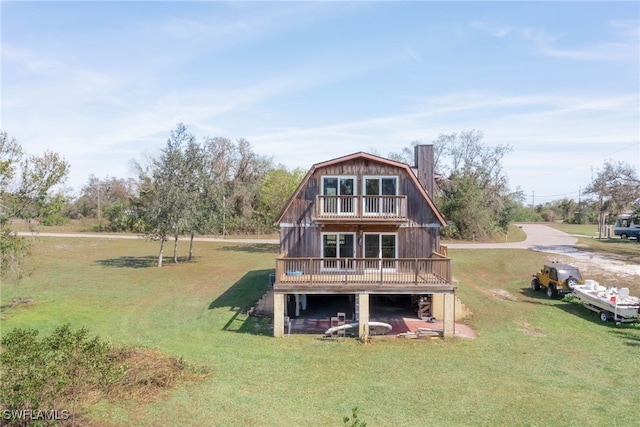 373 Hile Ln, Punta Gorda, FL 33982 - rear view of property featuring a balcony, a gambrel roof, a lawn, and a wooden deck