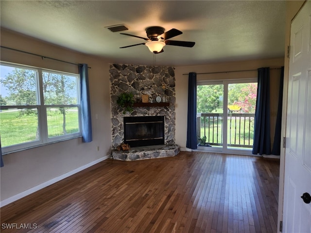 373 Hile Ln, Punta Gorda, FL 33982 - unfurnished living room featuring wood-type flooring, ceiling fan, a stone fireplace, and baseboards
