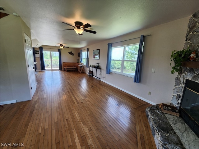 373 Hile Ln, Punta Gorda, FL 33982 - living area with hardwood / wood-style floors, ceiling fan, a stone fireplace, and baseboards