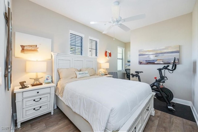 bedroom featuring baseboards, dark wood finished floors, and a ceiling fan