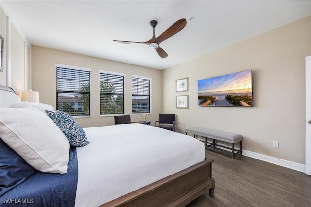 bedroom with dark wood-type flooring, ceiling fan, and baseboards