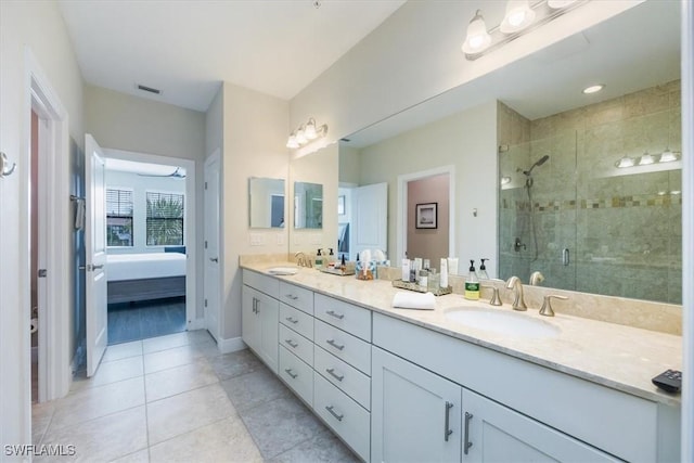 bathroom with ensuite bathroom, double vanity, a sink, and a shower stall