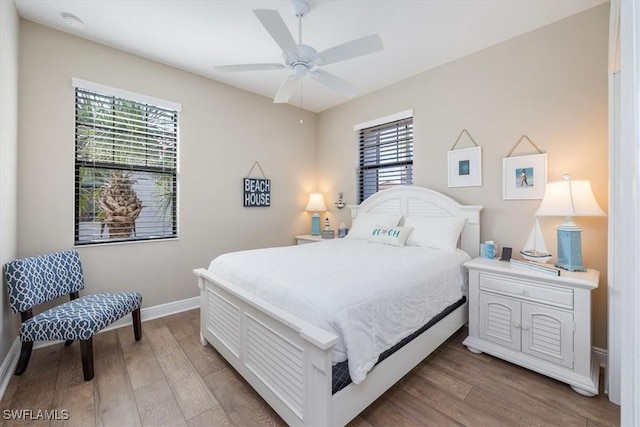 bedroom with ceiling fan, baseboards, and wood finished floors