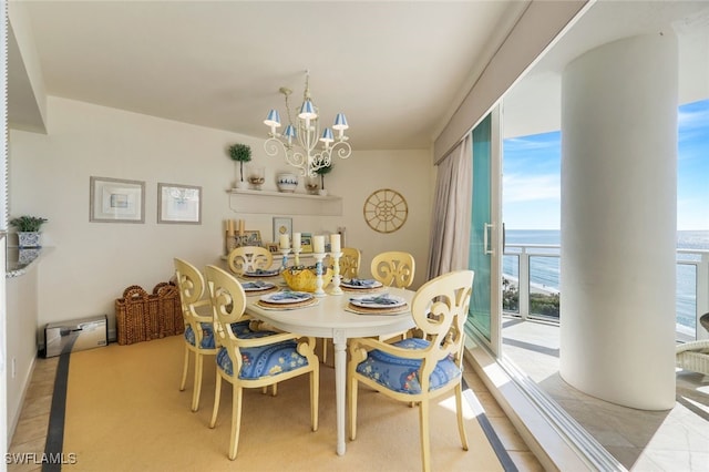 dining area with a water view and an inviting chandelier