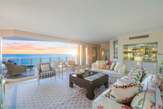 living room featuring a water view and crown molding