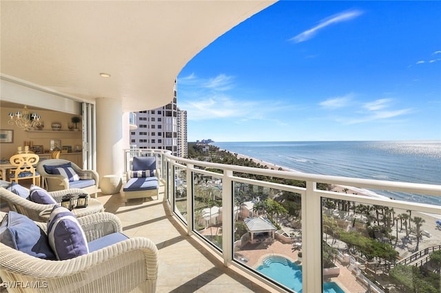 balcony featuring a water view and a beach view