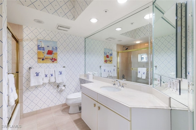 full bathroom featuring tile patterned floors, toilet, vanity, and bath / shower combo with glass door