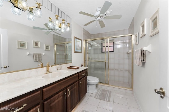 bathroom with a shower with shower door, tile patterned flooring, vanity, ceiling fan, and toilet