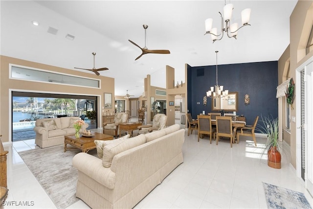 tiled living room with ceiling fan with notable chandelier and high vaulted ceiling