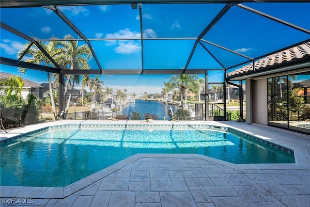 view of pool with a patio, a water view, and glass enclosure