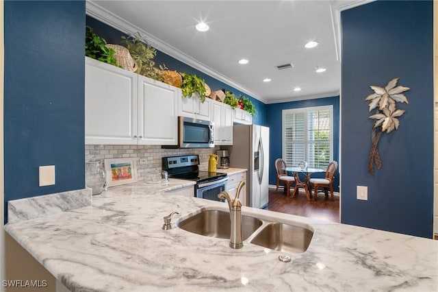 kitchen with visible vents, appliances with stainless steel finishes, light stone counters, crown molding, and a sink