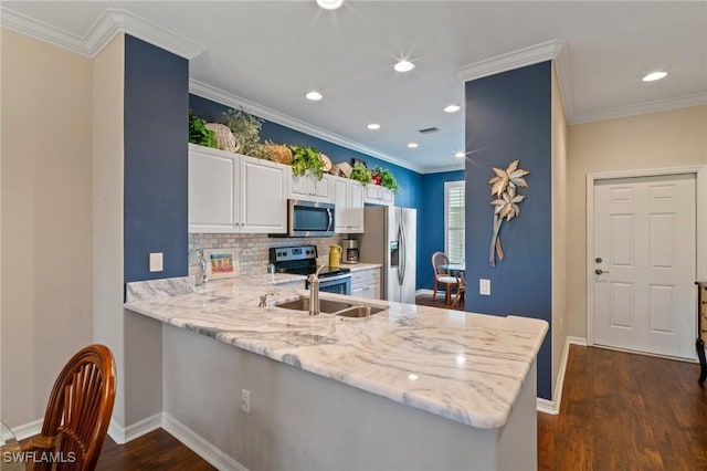 kitchen featuring dark wood-type flooring, baseboards, white cabinets, ornamental molding, and appliances with stainless steel finishes