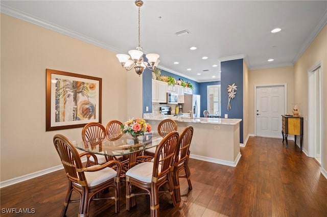 dining area with ornamental molding, visible vents, and dark wood finished floors