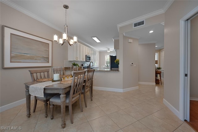 tiled dining area featuring sink, a chandelier, and crown molding